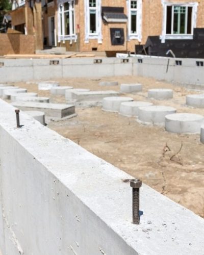 New house foundation with partially complete in background